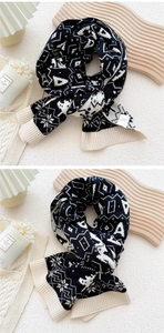 Close-up of winter knit scarf with black and white snowflake patterns and ribbed edges
