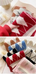 Detail of diamond pattern knit scarves in various colors with soft wool texture