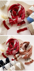 Detail of diamond pattern knit scarves showing thick wool texture and ribbed edges