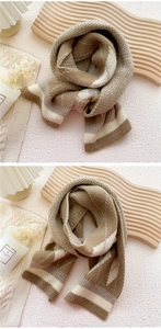 Detail of diamond check knitted scarf with earth-tone stripes and soft wool texture