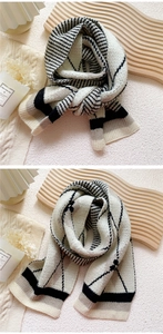 Close-up of black and white diamond lattice knit scarf with thick stripes and soft texture