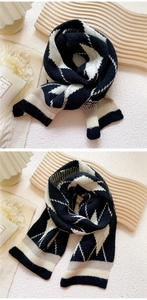 Close-up of thick knit diamond pattern scarf with soft texture and black contrast edges