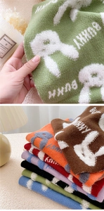 Detailed macro view of bunny jacquard texture and colorful knitted scarves stack
