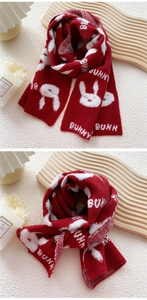 Detail of red knit scarf featuring white bunny patterns and warm textured weave