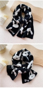 Close-up of black and white knit scarf featuring bunny motif and texture on a tray
