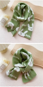 Close-up of green knitted scarf with white rabbit pattern and BUNNY lettering