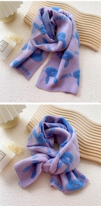Detail of lavender knit scarf with blue bunny pattern and soft fluffy texture