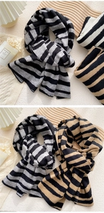 Close-up of striped knit scarves in grey-black and camel-black cashmere-like texture