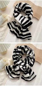 Close-up of thick black and white striped knit scarf showing soft texture and premium weave