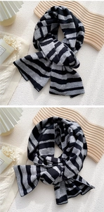 Detailed close-up of thick grey and black striped knit scarf with soft wool texture