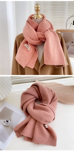 Gros plan détaillé de l'écharpe en maille rose corail épaisse avec texture douce et étiquette
