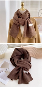 Détail d'une écharpe en maille marron foncé avec texture pelucheuse et étiquette tissée