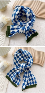 Détail de l'écharpe en tricot à losanges bleu et blanc avec bords côtelés vert foncé