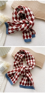 Détail d'une écharpe en tricot à losanges rouge et blanc avec bordure côtelée marine