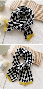 Détail macro d'une écharpe en tricot à losanges avec bordure jaune sur fond minimaliste