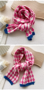 Détail de l'écharpe en tricot à motifs losanges rose et blanc et bords bleus