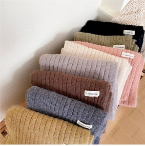 Détail macro de la maille et des étiquettes tissées sur diverses écharpes d'hiver