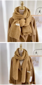 Détail de l'écharpe en maille côtelée jaune avec étiquette de marque sur tissu
