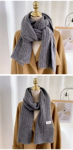 Détail d'une écharpe en maille grise à côtes verticales avec une étiquette de marque blanche