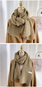 Texture de tricot détaillée de l'écharpe d'hiver vert olive associée à un manteau camel