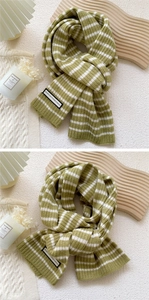 Gros plan sur une écharpe en tricot à rayures vert et blanc avec texture côtelée douce