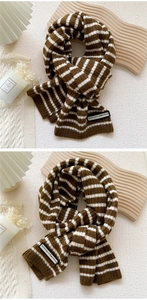 Détail d'une écharpe en maille rayée avec étiquette et décor hivernal chaleureux