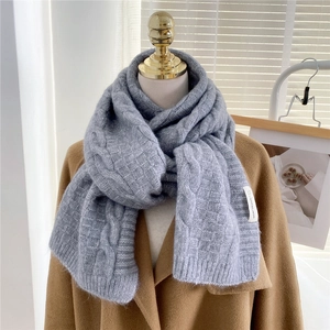 Detail of grey cable knit scarf showing thick textured weave and soft winter material