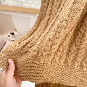 Detail of camel chunky cable knit scarf showing thick ribbed texture and warm fabric