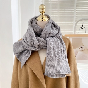 Close-up of gray chunky cable knit scarf showing thick wool texture and warm weave