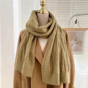 Detail of thick ginger yellow cable knit scarf with warm wool texture on a mannequin