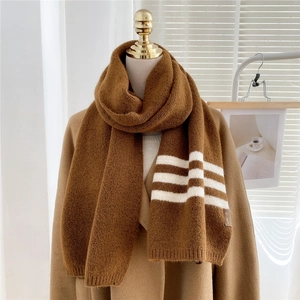 Close-up of thick caramel brown knit scarf featuring classic white stripe detail