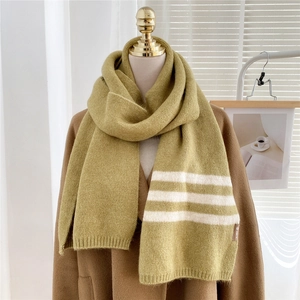 Close-up of olive green thick knit scarf with white stripes and textured finish