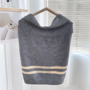 Detailed knit texture of a thick striped grey shawl draped on a wooden hanger