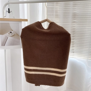 Close-up of the brown knitted material with white stripe detail and elastic texture