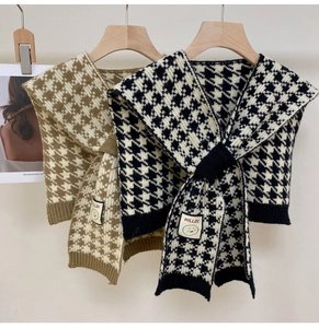 Detail of checkered knit shawl with retro houndstooth pattern and chic brand label