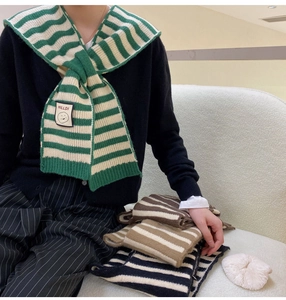 Close-up of knitted shawl collection featuring striped patterns and vintage smile patches