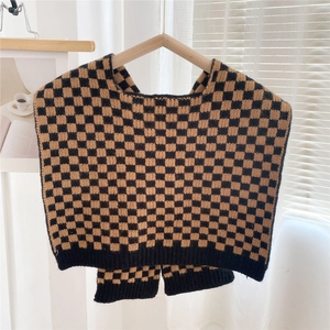 Detail of checkered knit shawl with yellow and black patterns and ribbed hem detail