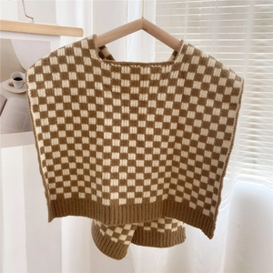 Close-up of thick knit vest with brown checkered pattern and ribbed edge detail
