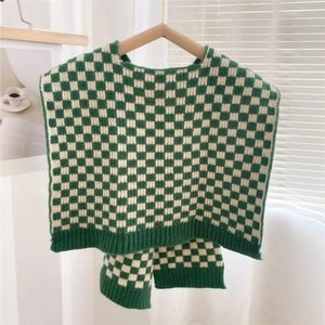 Close-up of green and cream checkerboard knit pattern with ribbed edges and soft texture