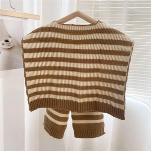 Close-up of brown and beige striped knit baby vest with ribbed edges on a wooden hanger