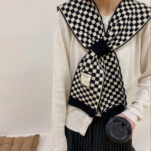 Classic black and white checkerboard knit scarf with minimalist smile patch and soft texture