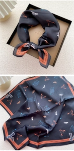 Detail of square silk scarf with western skull patterns inside a premium black gift box