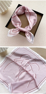 Detail of pink silk square scarf with abstract lines and elegant English text design