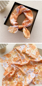 Detail of silk square scarf with daisy floral print in orange and purple tones