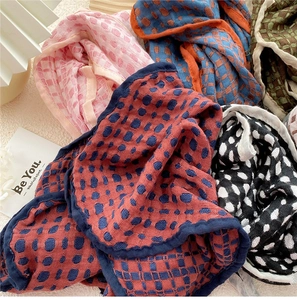 Detail shot of multi-colored cotton linen scarves with grid patterns and pleated texture