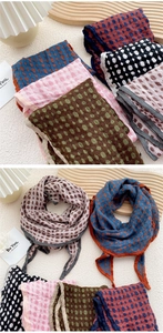 Close-up of double-sided polka dot and plaid scarves with textured seersucker fabric finish