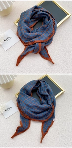 Detail of navy blue cotton linen scarf with orange polka dots and stitched edges
