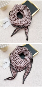 Detail of soft linen scarf featuring brown polka dots and grey stitched edges