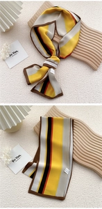 Detailed view of a striped silk scarf tied elegantly on a wavy wooden display board