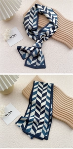 Detail of chevron pattern silk scarf tied on decorative stand with a minimalist quote card